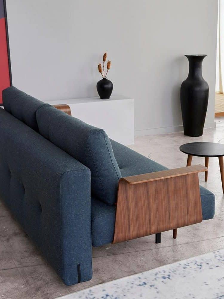 A blue comfortable sofa with brown inserts on the side